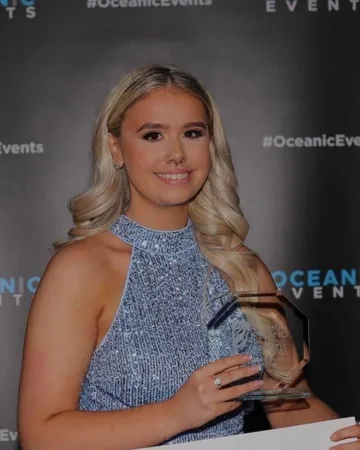 Ami smiling with her Junior Stylist of the Year trophy at the Northern Ireland Hair and Beauty Awards 2023